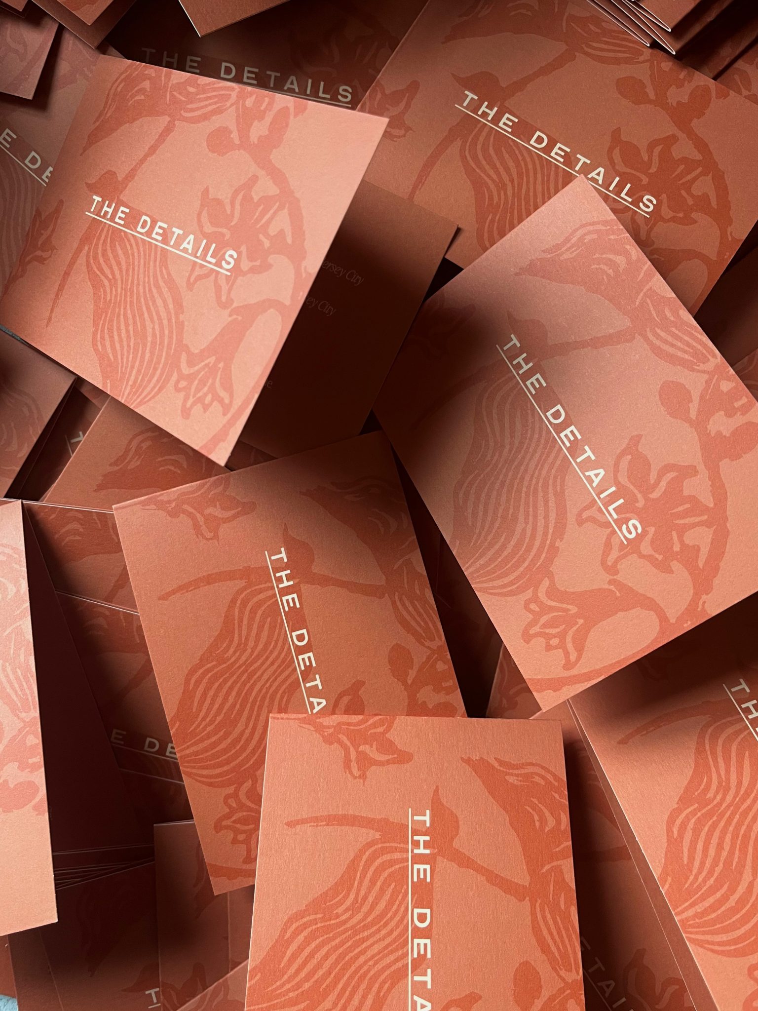 Orange wedding invitation suite details cards with a layered tonal leaf print.