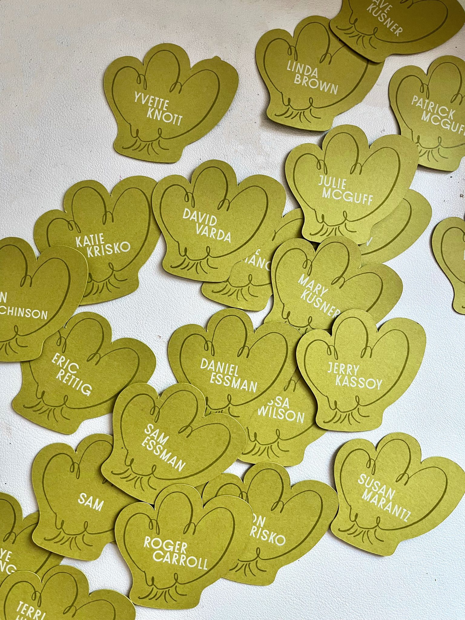 Custom cutout green place cards with guest names in white ink