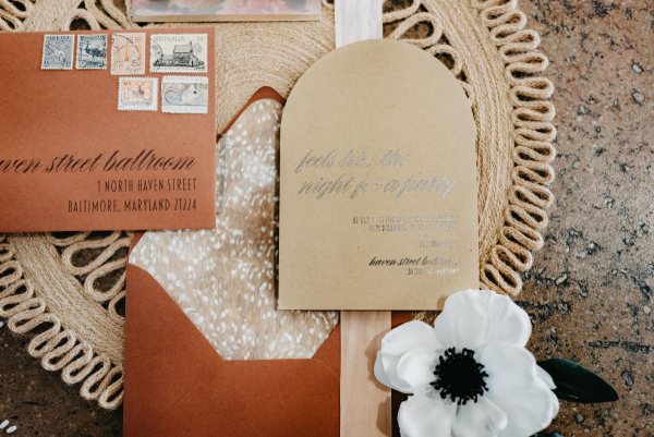 Modern wedding invitations with ribbon and floral vellum overlay. Modern calligraphy, vintage stamps, and envelope liner